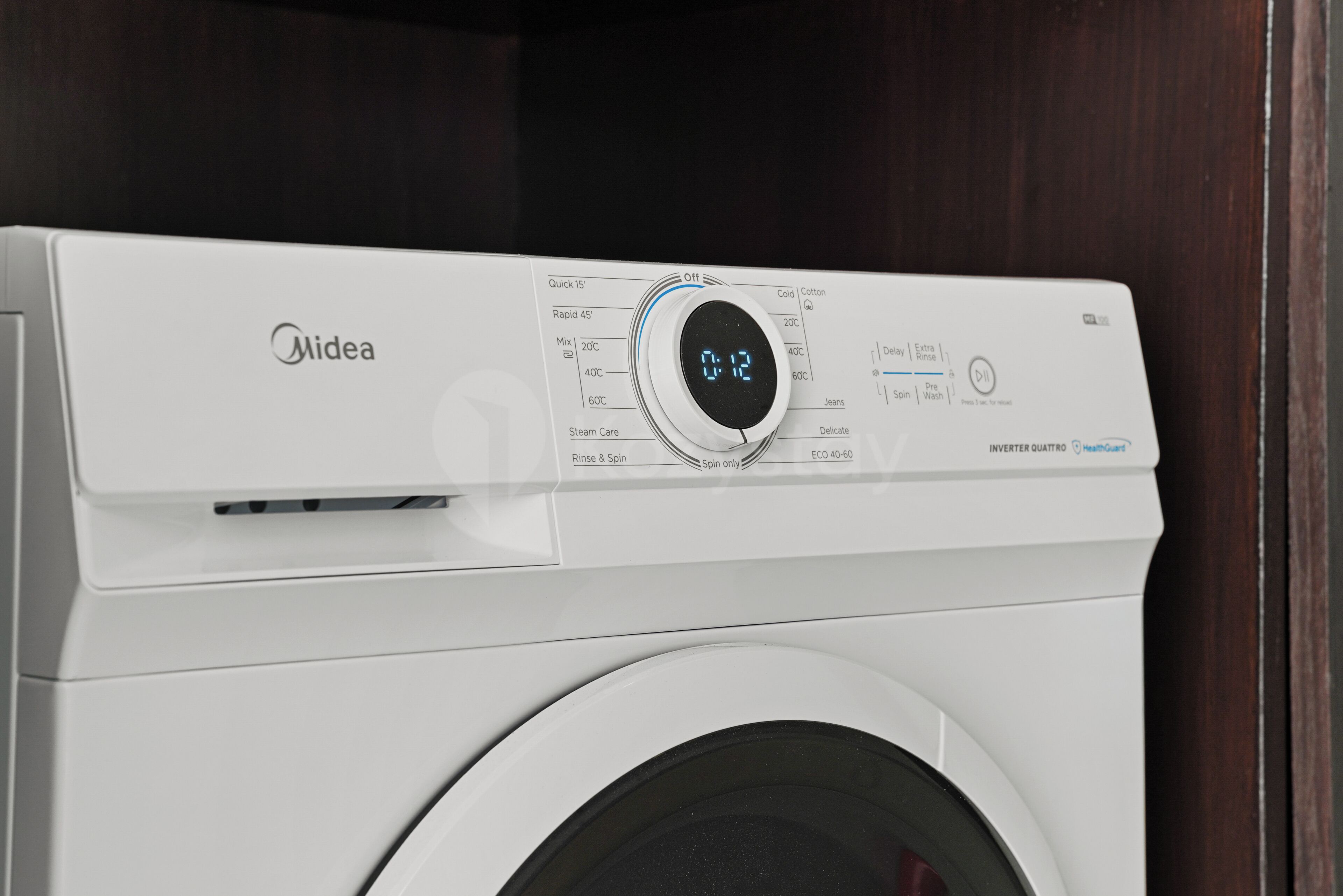 Een witte Midea wasmachine met een digitaal display en bedieningspaneel.