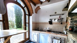 A kitchen with a large window, a stove, and a sink. - Country House 'Le Mulina' with Wi-Fi (Barberino di Mugello)