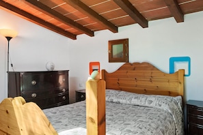 A bedroom with a wooden bed, a dresser, a nightstand, a lamp, and a framed picture on the wall. - Country House 'Le Mulina' with Wi-Fi (Barberino di Mugello)