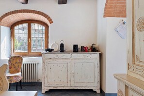 A room with a white cabinet, a radiator, a window with a brick arch, and a chair with a floral pattern. - Country House 'Le Mulina' with Wi-Fi (Barberino di Mugello)
