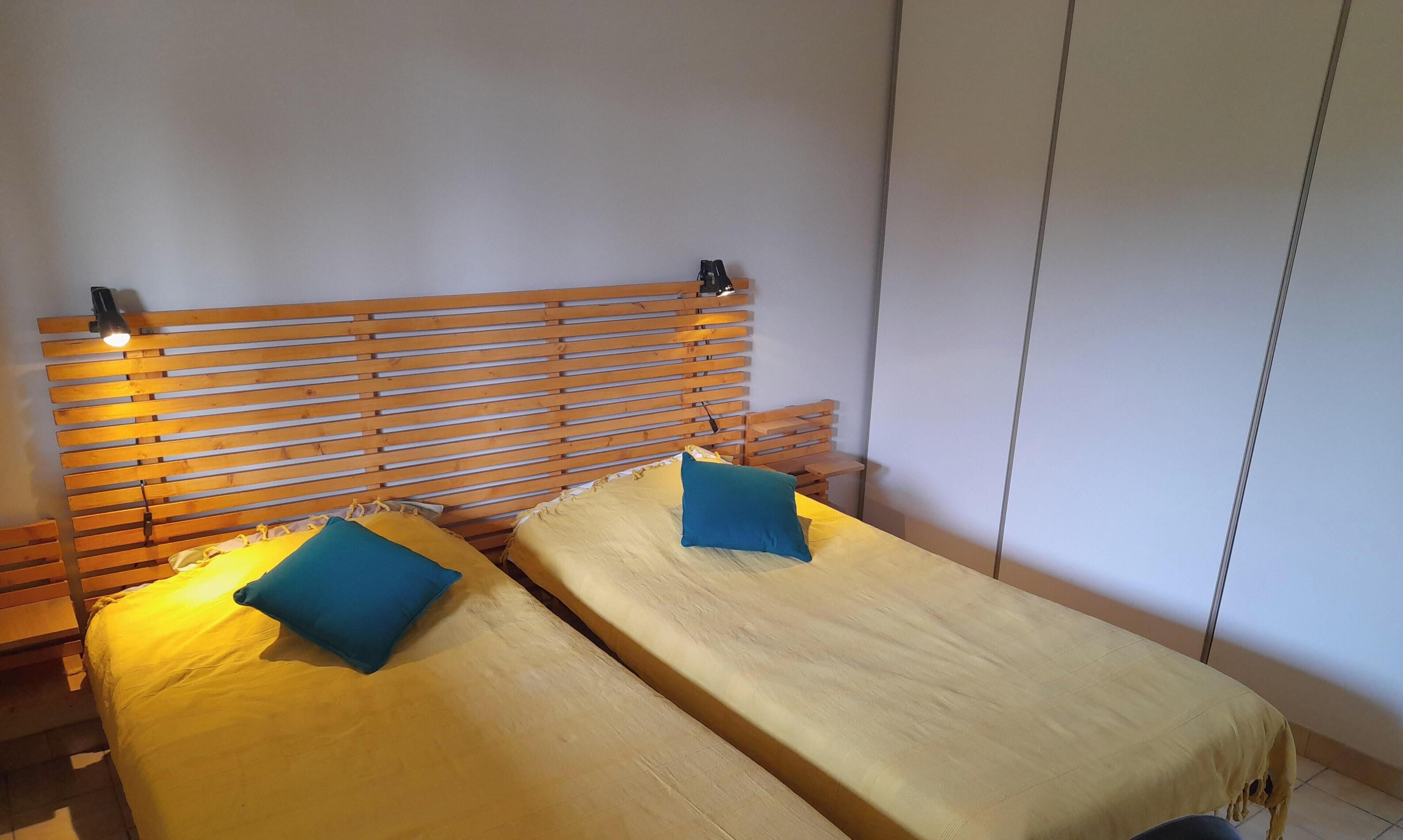 Una habitación con dos camas, cada una con almohada y cabecero.