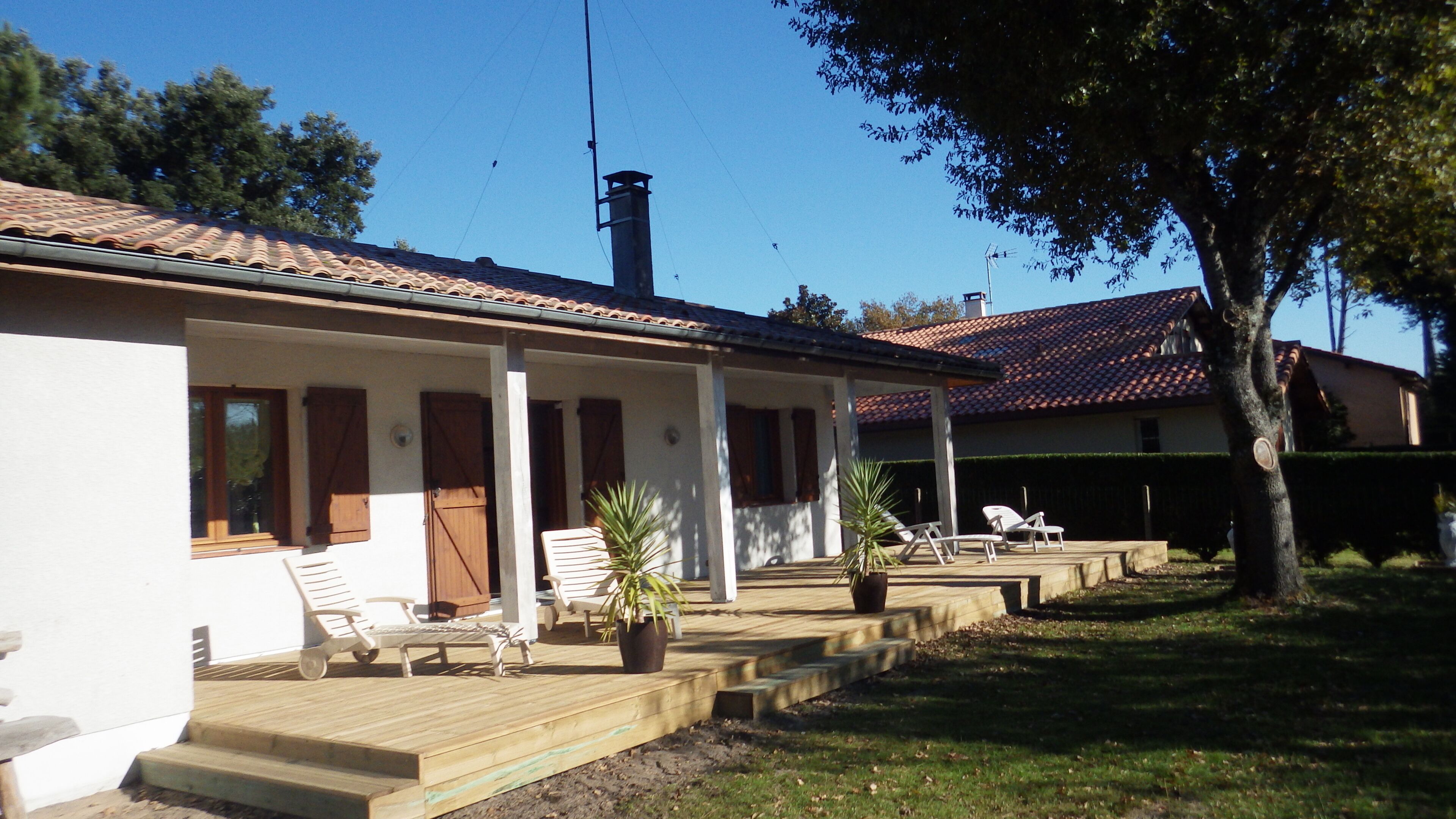 A house with a covered porch, outdoor seating, and a garden.