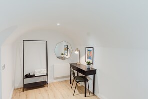 A modern, minimalistic room with a desk, chair, and a large mirror. - Joivy Vaults Studios and Apartments (Edinburgh)