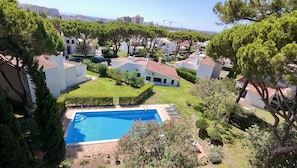 A residential area with a swimming pool surrounded by greenery and white buildings. - Vilamoura Vintage Villa by Homing (Loulé)