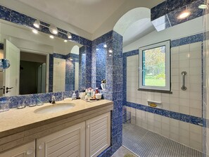 A bathroom with a double sink vanity, a large mirror, and a shower area. - Vilamoura Vintage Villa by Homing (Loulé)
