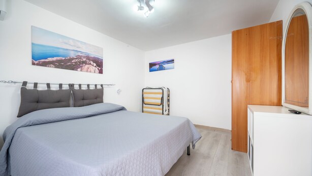 A bedroom with a bed, a wardrobe, a mirror, and two wall-mounted pictures. - CASA SAURO 10 (Avola)