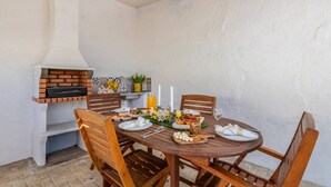 Ein runder Holztisch, gedeckt für eine Mahlzeit, mit einem Backofen und dekorativen Elementen an der Wand.