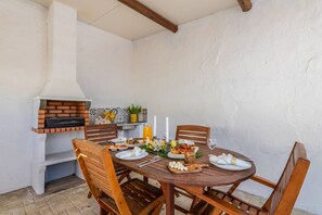 Ein runder Holztisch, gedeckt für eine Mahlzeit, mit einem Backofen und dekorativen Elementen an der Wand.