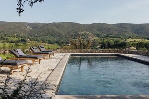 A rectangular pool with lounge chairs and a view of a hilly landscape. - Le Pavadou B&B (Methamis)