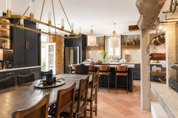 A modern kitchen with dark cabinetry, a central island, and pendant lighting.