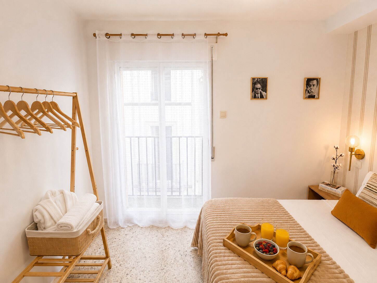 Un dormitorio con cama, una bandeja con cosas para el desayuno, un perchero y una ventana con vistas.
