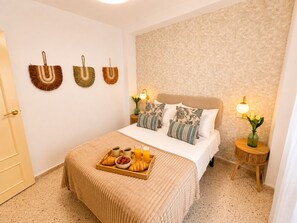 A neatly arranged bedroom with a bed, bedside lamps, a tray with breakfast, and decorative wall hangings. - Seville City Center - Alcázar, Giralda, and Cathedral just 1 minute away - Elegant - Sleeps 4 (Sevilla)
