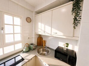 A kitchen with white cabinets, a stainless steel sink, a microwave, a toaster, and a kettle. - Seville City Center - Alcázar, Giralda, and Cathedral just 1 minute away - Elegant - Sleeps 4 (Sevilla)