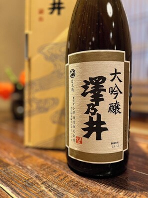 Una botella de sake japonés con etiqueta, sobre una superficie de madera.