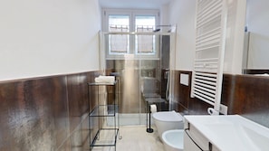 A bathroom with a glass shower enclosure, a white toilet, and a white sink.