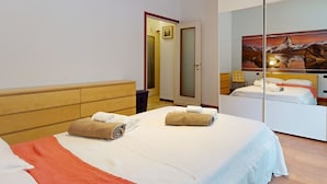 A hotel room with a bed, a wardrobe, a mirror, and a painting on the wall. - Come a Casa Tua Milano (Milano)