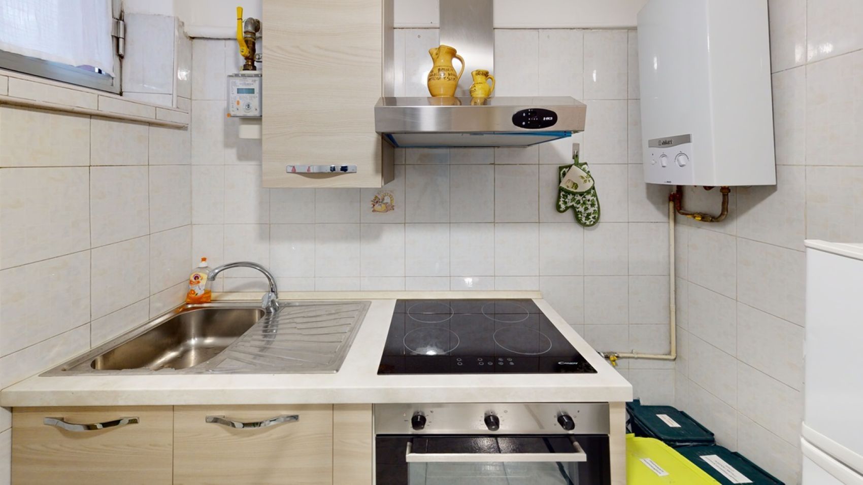 Une cuisine équipée d’un évier, d’une cuisinière et d’un chauffe-eau.