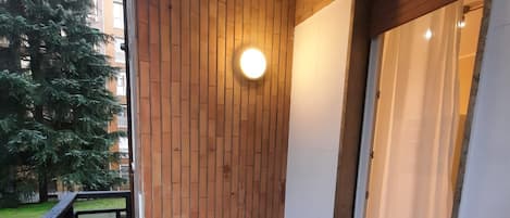 A balcony with a wooden wall, a table, and a chair.