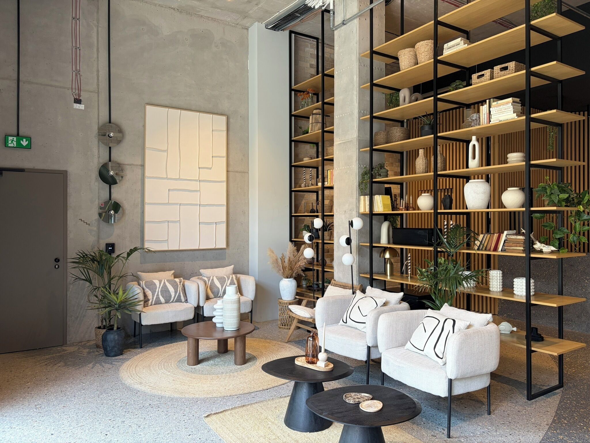 A modern lounge area with sofas, a coffee table, and a bookshelf filled with decorative items.