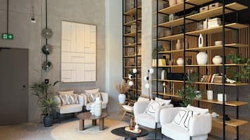 A modern lounge area with sofas, a coffee table, and a bookshelf filled with decorative items.