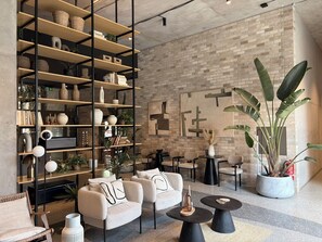 A modern interior with a brick wall, a large bookshelf, and comfortable seating.
