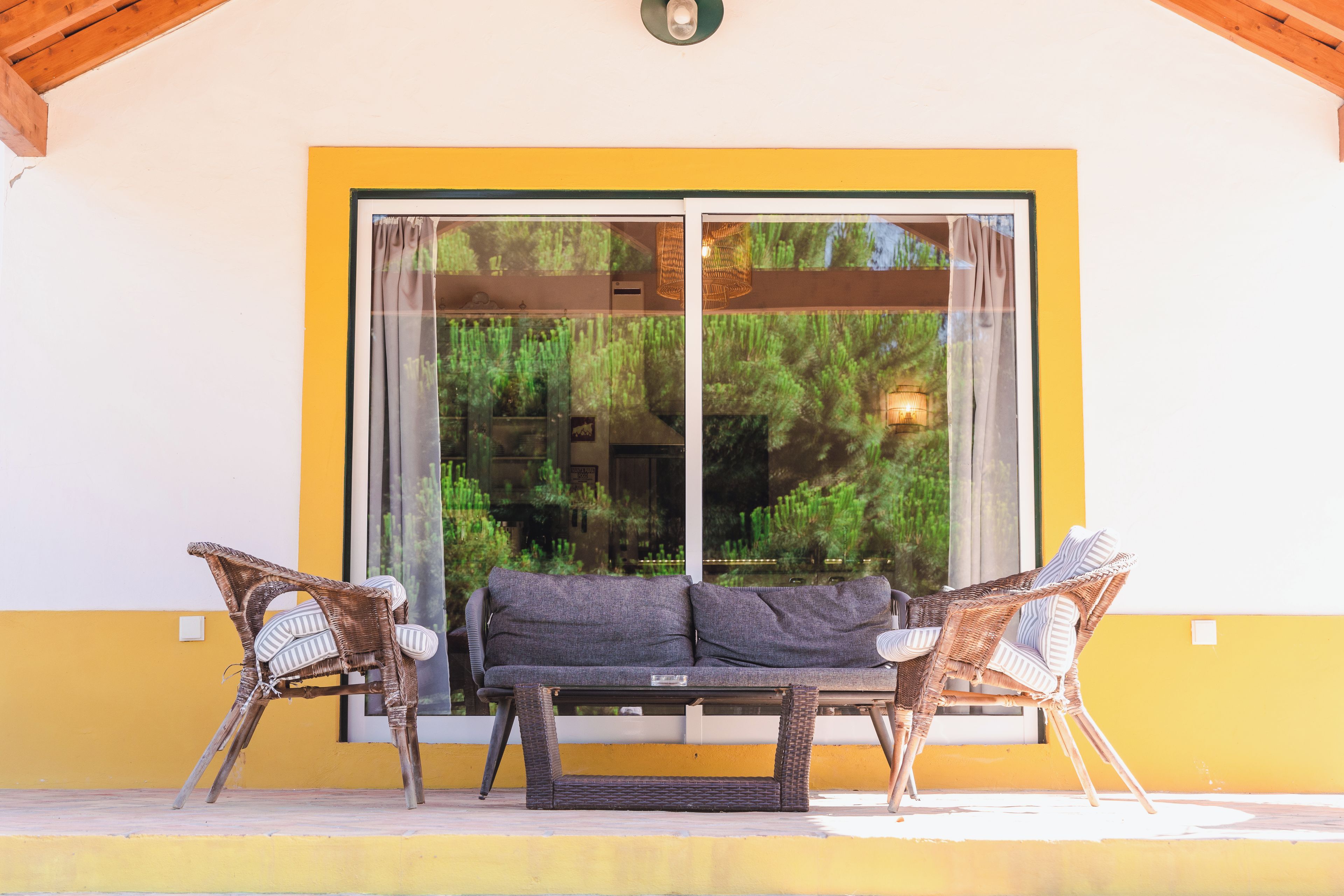 Un patio con mobiliario de mimbre y una puerta corrediza de vidrio.