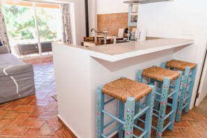 Una cocina con barra, una mesa de comedor y un sofá.