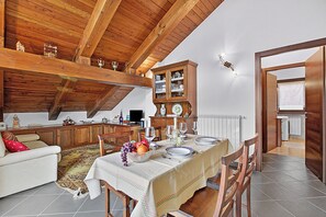 Ein Essbereich mit Tisch für vier Personen, Holzschränken und einer gemütlichen Sitzecke.