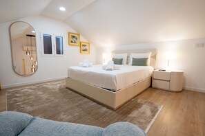 A modern bedroom with a large bed, bedside tables, a mirror, and framed pictures on the wall.