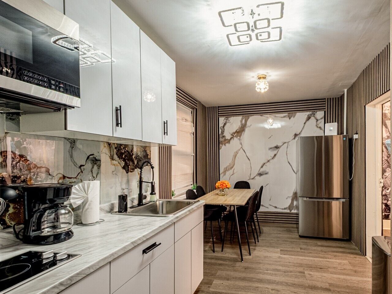 Una cocina moderna con estufa integrada, cafetera y refrigerador.