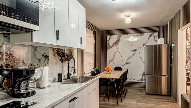 Una cocina moderna con estufa integrada, cafetera y refrigerador.