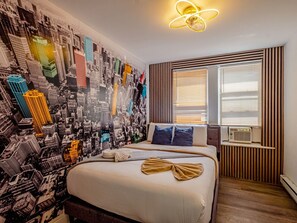 Une chambre d’hôtel avec un lit, un mur décoré d’une vue sur la ville, une fenêtre avec des stores et un luminaire au plafond.