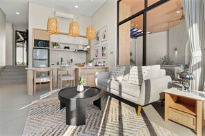 A modern living room with a sofa, coffee table, and dining area.