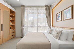 A modern bedroom with a large bed, a wardrobe, and a view of the outdoors. - Avelora Villa by Kozystay - Jimbaran (Badung)