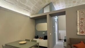 A compact living space with a dining area, kitchenette, and a sofa. - Apartment in the heart of the city (Taranto)
