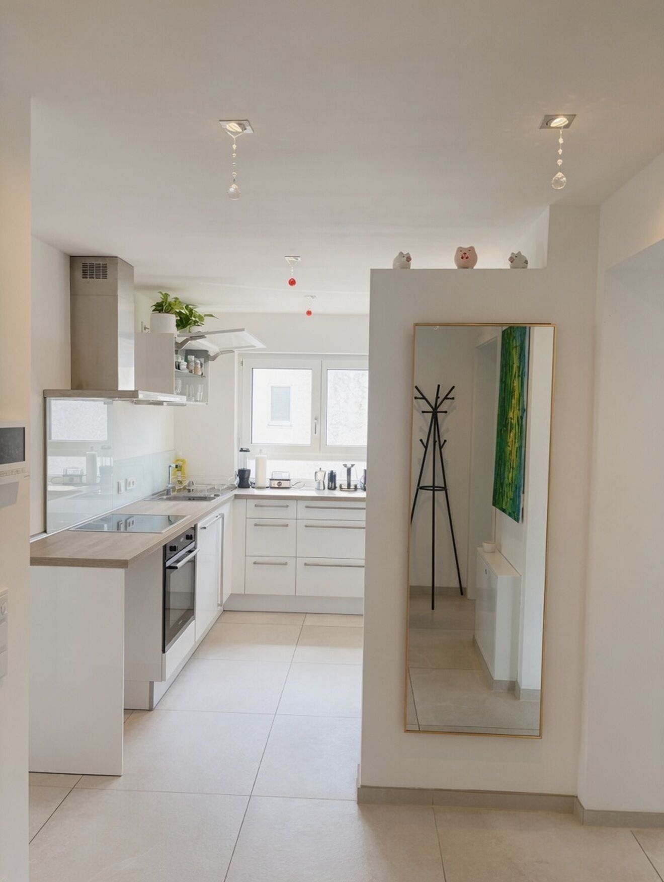 Une cuisine moderne avec des meubles blancs, un îlot central et une vue sur la salle à manger.