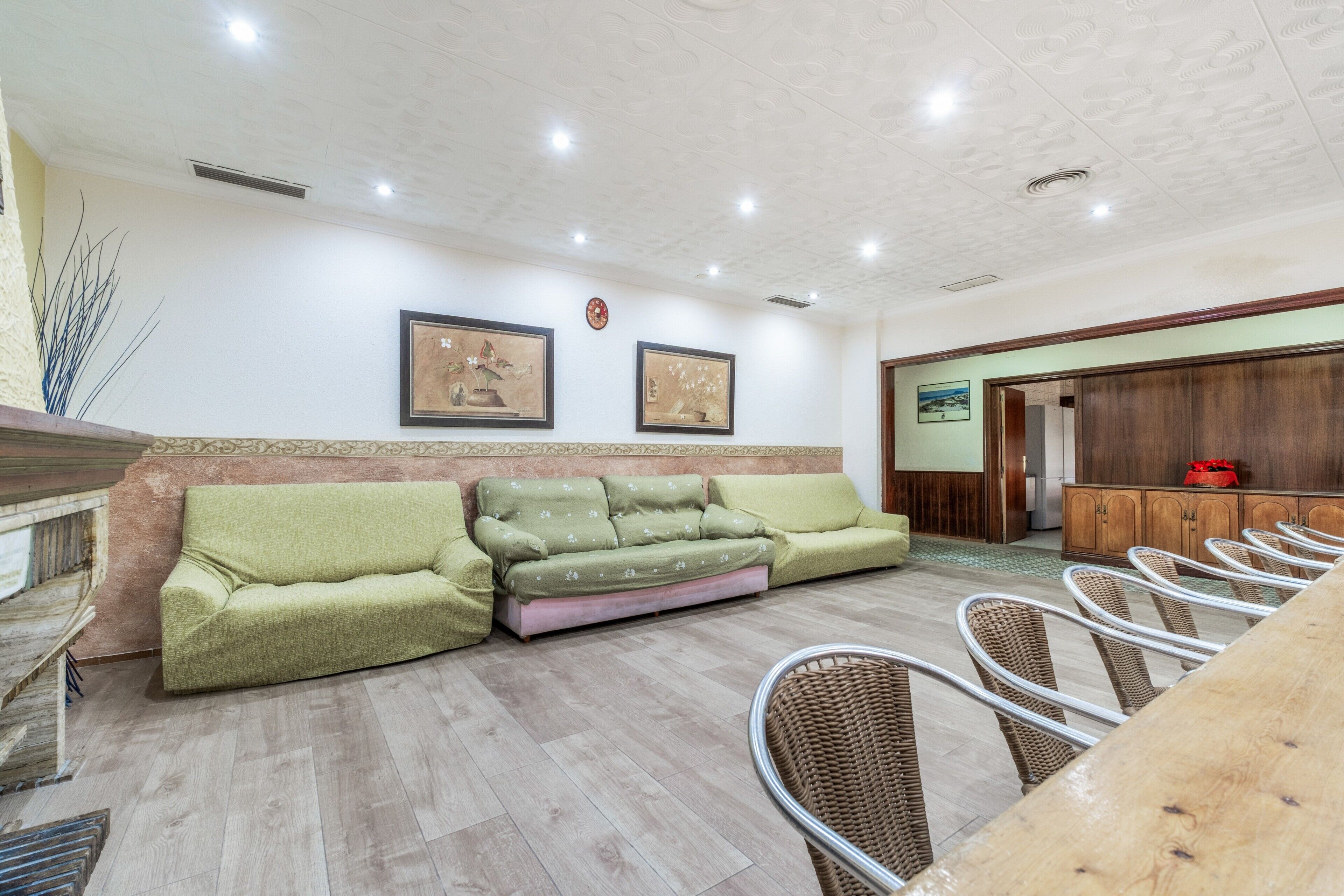 A reception area with a sofa, chairs, and a wooden cabinet.