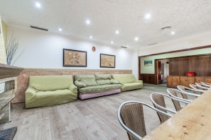 A reception area with a sofa, chairs, and a wooden cabinet.