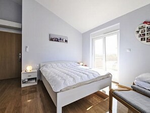 A bedroom with a bed, bedside tables, a bench, and a window. - Vacation home Carina by Interhome (Poreč/Kaštelir)