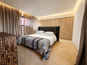 A modern bedroom with a bed, curtains, a wooden headboard, and a wooden floor. - Exceptional villa overlooking the Amelkis Golf Course - 6 bedrooms, hammam, and indoor pool (Marrakech)