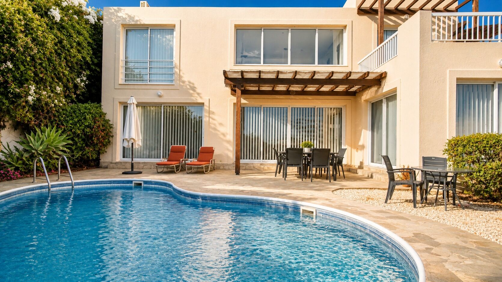 A swimming pool with lounge chairs and a patio area.