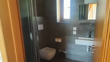 Ein Badezimmer mit Dusche, Toilette und Waschbecken.