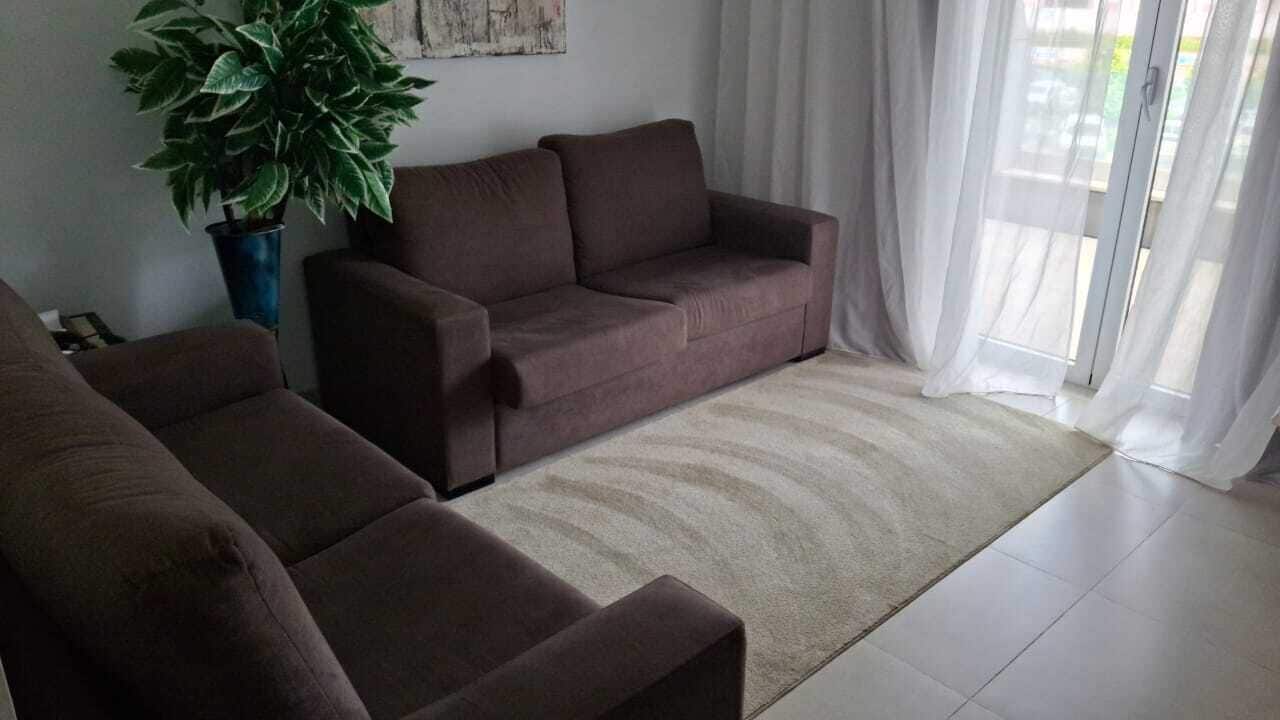 Uma sala de estar com um sofá e um vaso de planta.