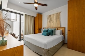 A modern bedroom with a large bed, a ceiling fan, and a view of the outdoors. - Coastal Condo with Rooftop Infinity Pool & Beach Club – La Cruz, Nayarit (Bahia de Banderas)