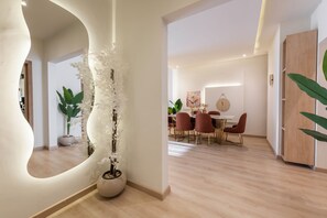A modern interior with a dining area, a large mirror, and a decorative plant arrangement. - Premium 3BR Residence in Sodic Eastown, New Cairo /Sleeps 8 (Cairo Governorate)