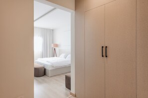 A modern bedroom with a bed, bedside table, and a wardrobe. - Premium 3BR Residence in Sodic Eastown, New Cairo /Sleeps 8 (Cairo Governorate)