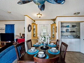 A compact living space with a dining area, kitchen, and a television. - Perdido Hideaway in Pensacola (Pensacola)