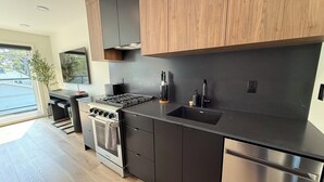 Une cuisine moderne équipée d’une cuisinière, d’un four et d’un lave-vaisselle en acier inoxydable.