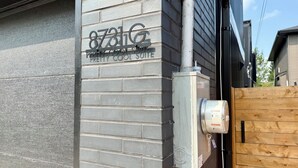 Un bâtiment à l’extérieur en briques grises, sur lequel on peut lire l’inscription : « 8731G, une suite vraiment sympa ».