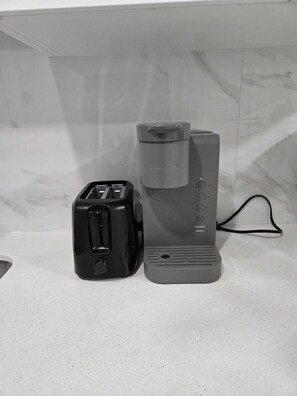 Eine Küche mit einem Toaster und einer Kaffeemaschine auf einer Arbeitsplatte.
